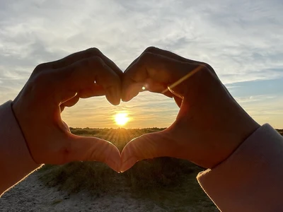 Ein Herz mit einer Hand wo die Sonne in der Mitte des Herzen zu sehen ist. Camping Skagen